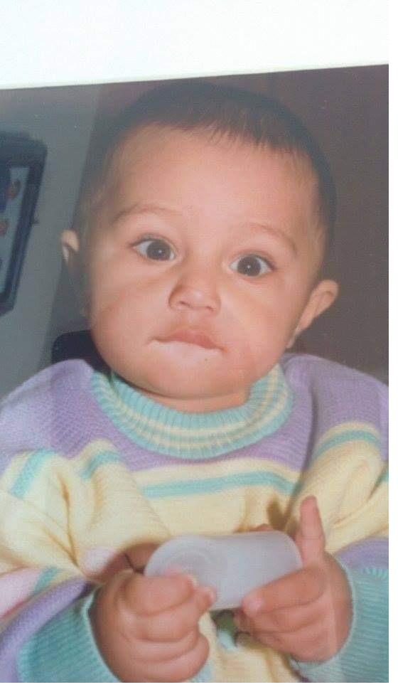 Devanshu as a baby in a pastel striped sweater